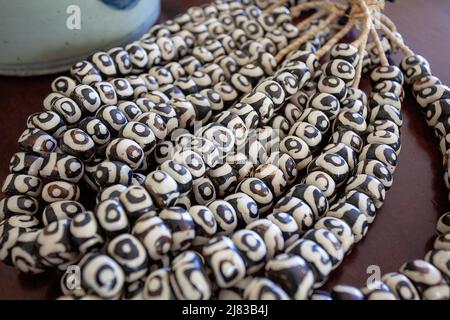 Contrasto naturale: Perline in ceramica su corda di canapa Foto Stock