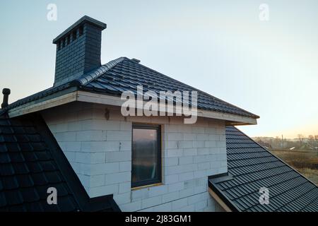 Vista aerea di casa incompiuta con pareti in calcestruzzo leggero aerato e telaio del tetto in legno rivestito con piastrelle metalliche in costruzione. Foto Stock