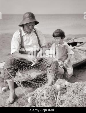 1920S GIOVANE RAGAZZO SEDUTO IN BARCA ACCANTO AL MAGGIORE FISHERMAN WEARIING A SOU’WESTER HAT RIPARAZIONE DELLE SUE RETI DA PESCA - J279 HAR001 HARS ANZIANO FISHERMAN SPAZIO RURALE COPIA VOI AMICIZIA MEZZA LUNGHEZZA PERSONE ISPIRAZIONE MASCHI B&W FELICITÀ VECCHIAIA OLDSTERS ALTO ANGOLO OLDSTER LA SUA CONOSCENZA RETI GIOVANI E ANZIANI RIPARANDO CONCETTUALE CONNESSIONE ACCANTO A ANZIANI CRESCITA GIOVANI GIOVANI TOGETHERNESS GIOVANE NERO E. BIANCA ETNIA CAUCASICA HAR001 VECCHIO STILE Foto Stock