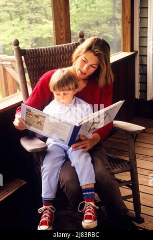 1990S DONNA MADRE CHE LEGGE AL RAGAZZO SUO FIGLIO MENTRE SI SIEDE IN SEDIA SU UN PORTICO ESTIVO SCHERMATO - KJ13381 NET002 HARS 1 GIOVANE COMUNICAZIONE GIOVANE ADULTO DONDOLO LAVORO DI SQUADRA FIGLI FAMIGLIE GIOIA LIFESTYLE GENITORI FEMMINE RURALE VITA COPIA SPAZIO SIGNORE PERSONE ISPIRAZIONE PRENDERSI CURA DEI MASCHI OBIETTIVI FELICITÀ ALTO ANGOLO DI CONOSCENZA ORGOGLIO CRESCITA ELEGANTE GIOVANI MOMS LETTURE SCHERMATE TOGETHERNESS GIOVANE ADULTA DONNA ETNIA CAUCASICA VECCHIO STILE Foto Stock