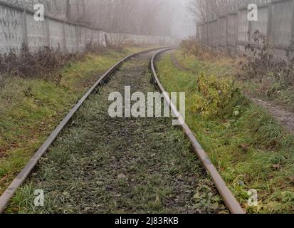 Una vecchia ferrovia a un semi-abbandonato struttura chiusa in autunno nella nebbia. Foto Stock