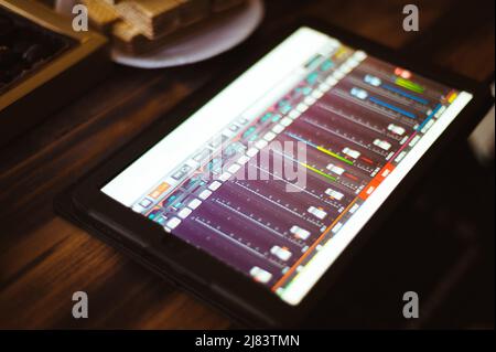 La miscelazione di musica sul tablet con strumenti musicali elettronici concept Foto Stock