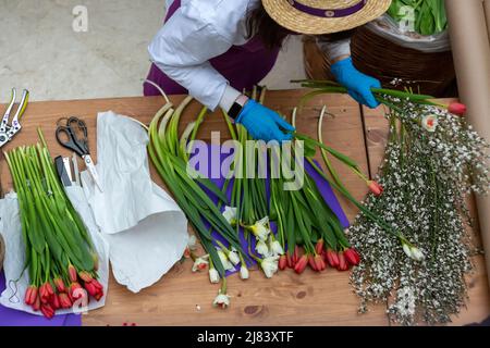 Mosca, Russia. 8th marzo 2022 il fiorista colleziona un bouquet in vendita presso un mercato di fiori presso il centro commerciale Petrovsky Passage in occasione della Giornata Internazionale della Donna a Mosca, Russia Foto Stock