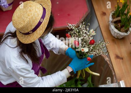Mosca, Russia. 8th marzo 2022 il fiorista colleziona un bouquet in vendita presso un mercato di fiori presso il centro commerciale Petrovsky Passage in occasione della Giornata Internazionale della Donna a Mosca, Russia Foto Stock