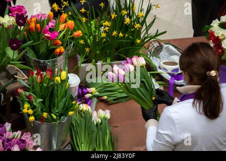 Mosca, Russia. 8th marzo 2022 il fiorista colleziona un bouquet in vendita presso un mercato di fiori presso il centro commerciale Petrovsky Passage in occasione della Giornata Internazionale della Donna a Mosca, Russia Foto Stock