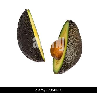 Intero e tagliato nero avocado Hass isolato su sfondo bianco. Foto Stock