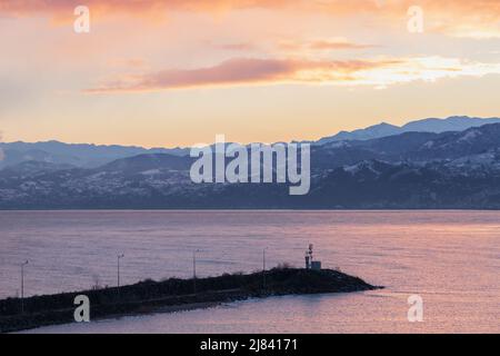 Arakli, Trabzon, Turchia. Vista sulla costa con faro all'ingresso del piccolo porto di pescatori. La costa del Mar Nero al mattino Foto Stock