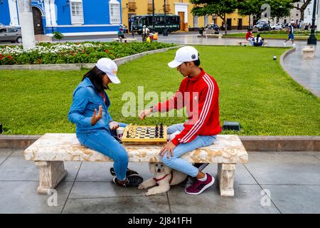 Una giovane coppia che gioca a scacchi nella Plaza De Armas, Trujillo, la Libertad Regione, Perù. Foto Stock
