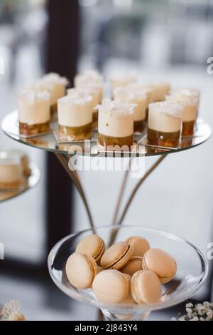 Dolci luminosi in tazze sul tavolo da nozze e amaretti Foto Stock