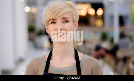 Adulto maturo di mezza età 40s donna ristorante caffetteria proprietario guardando macchina fotografica sorridendo toothy amichevole sorriso felice donna cameriera donna Foto Stock