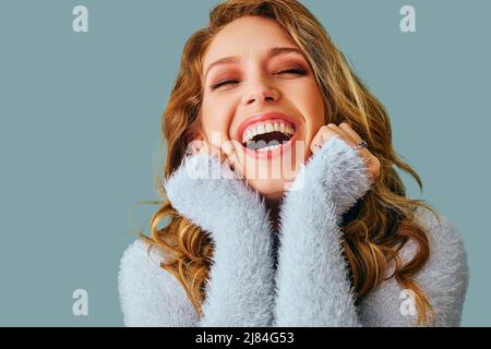 ritratto di bella giovane adulta sorridente donna con capelli ricci lunghi studio Foto Stock