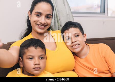 mamma che fotografa i suoi figli con il cellulare Foto Stock