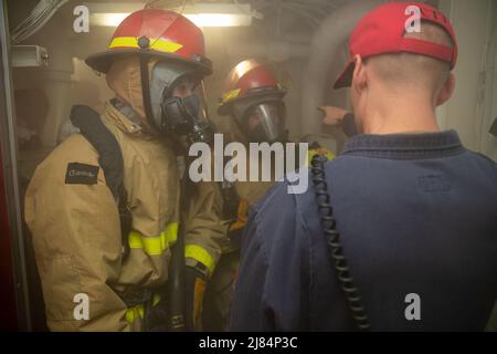 I marinai assegnati a USS Gerald R. Ford (CVN 78) combattono un incendio simulato durante un'esercitazione di emergenza in porto a bordo di Ford, 11 maggio 2022. Ford e USS George H.W. Bush (CVN 77) ha partecipato a un'evoluzione a due vettori, progettata per mantenere e migliorare le capacità di controllo dei danni di entrambi i vettori aerei. Ford è in porto Naval Station Norfolk preparazione per il suo prossimo periodo in corso. (STATI UNITI Foto della Marina di comunicazione di massa Seaman Apprentice Rajah Lee Thornton) Foto Stock