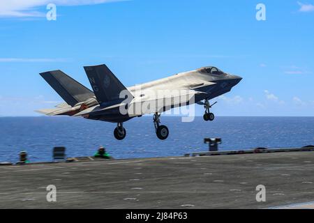 PHILIPPINE SEA (12 maggio 2022) un F-35C Lightning II, assegnato ai 'Cavalieri neri' di Marine Fighter Attack Squadron (VMFA) 314, lancia dal ponte di volo della portaerei di classe Nimitz USS Abraham Lincoln (CVN 72). Abraham Lincoln Strike Group è in fase di implementazione pianificata nell'area delle operazioni della flotta USA 7th per migliorare l'interoperabilità attraverso alleanze e partnership, fungendo da forza di risposta pronta a supportare una regione indopacifica libera e aperta. (STATI UNITI Foto Navy di Mass Communication Specialist 3rd Classe Javier Reyes) Foto Stock