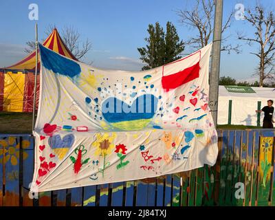 Przemysl, Polonia. 12th maggio 2022. Un'opera d'arte con un cuore nei colori blu e giallo dell'Ucraina, realizzata da volontari e bambini presso il centro di elaborazione degli aiuti umanitari Tesco a Przemysl, in Polonia, vicino al confine con Medyka. Si trova sulla recinzione dell'area giochi per bambini. (Credit Image: © Amy Katz/ZUMA Press Wire) Foto Stock