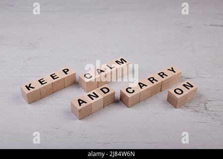 Blocchi di legno che costruisce la parola MANTENERE CALMA E CONTINUARE Foto Stock