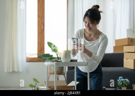 Felice giovane imprenditore proprietario imballaggio ordine a scatola di cartone, giovane proprietario donna Start up per il commercio in linea. Persone con lo shopping online PMI Foto Stock