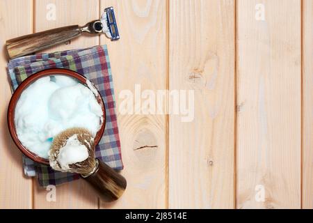 Dima con strumenti di rasatura, lama di rasoio, spazzola e gel sulla superficie in legno. Mockup con uno spazio di copia Foto Stock