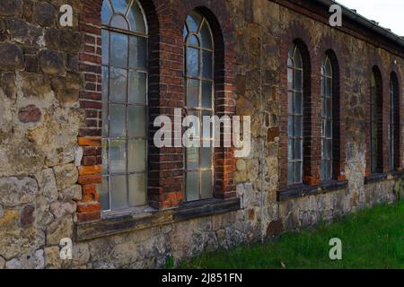 finestre e facciata in mattoni rossi di vecchio edificio abbandonato fabbrica in Germania Foto Stock