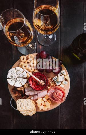 Antipasto di vino, salumi e piatto di formaggi, vista dall'alto su sfondo di legno. Foto Stock