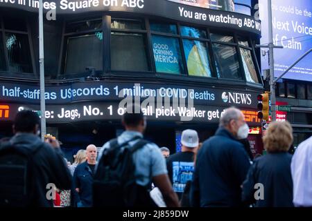 New York, Stati Uniti. 12th maggio 2022. I pedoni camminano di fronte a un notiziario di Times Square a New York, negli Stati Uniti, il 12 maggio 2022. PER ANDARE CON 'Xinhua Headlines: A manufactured dramy -- U.S. COVID-19 Deaths Reach 1 mln' Credit: Michael Nagle/Xinhua/Alamy Live News Foto Stock