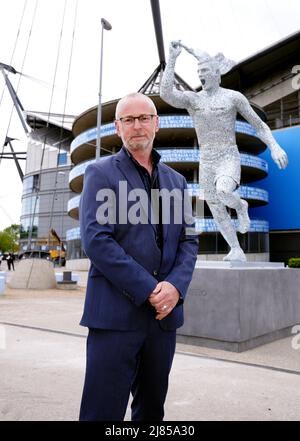 Lo scultore Andy Scott di fronte alla statua della leggenda del Manchester City Club, Sergio Aguero, fuori dall'Etihad Stadium di Manchester, per commemorare il decimo anniversario del primo titolo della Premier League del Club e l'iconico momento delle ‘93:20’. Data foto: Venerdì 13 maggio 2022. Foto Stock