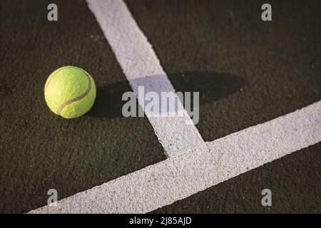 Primo piano ad angolo alto di pallina da tennis gialla da linee bianche sul campo da tennis, spazio copia Foto Stock