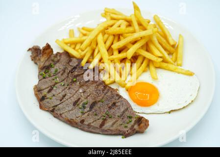 Piatto combinato di lombo di maiale con patate e uovo fritto Foto Stock