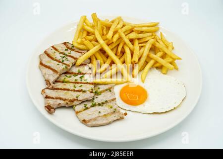 Piatto combinato di lombo di maiale con patate e uovo fritto Foto Stock