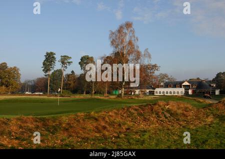 Vista dal lato del 9th Green con alberi d'autunno e colori d'autunno e il Clubhouse North Hants Golf Club, Fleet, Hampshire, Inghilterra Foto Stock