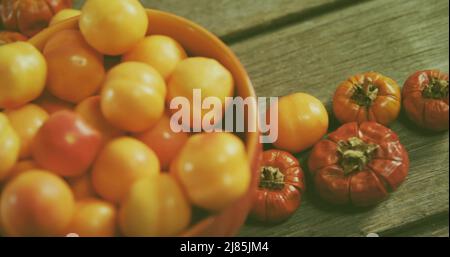 Immagine di braccia avvolte intorno al pianeta terra su pomodori freschi Foto Stock
