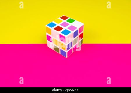 Cubo colorato con sfondo rosa e giallo, intelligenza e gioco del cervello, vista dall'alto, vista dall'alto del cubo Foto Stock