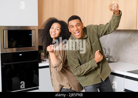 Ritratto di gioiosa coppia sposata ridendo a casa. Donna e il suo bell'uomo sorridendo e divertendosi insieme, guardando la macchina fotografica Foto Stock