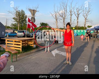 Przemysl, Polonia. 12th maggio 2022. Jenni di Berlino con il suo hoolah-hoop, un performer con il Circo mobile per la Pace e Cabuwazi, circo viaggiante per bambini, gioca con i bambini rifugiati e diverte adulti a Tesco, un centro ucraino di trattamento degli aiuti umanitari a Przemysl, in Polonia, vicino al confine con Medyka, Portare risate a centinaia di persone colpite dal dolore che sono appena arrivate nell'accogliente città di confine polacca da Kharkiv, Kiev, Odessa e altri luoghi sotto sequestro da parte degli invasori russi. (Credit Image: © Amy Katz/ZUMA Press Wire) Foto Stock