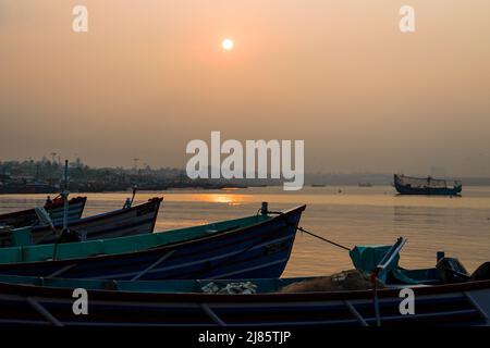 Fila di barche da pesca silhouetted sulla spiaggia in Tangassery, Kerala, India. Foto Stock