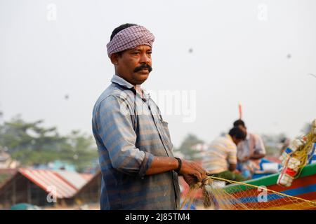 Ritratto di pescatore in piedi in barca con rete da pesca, Tangassery, Kerala, India. Foto Stock