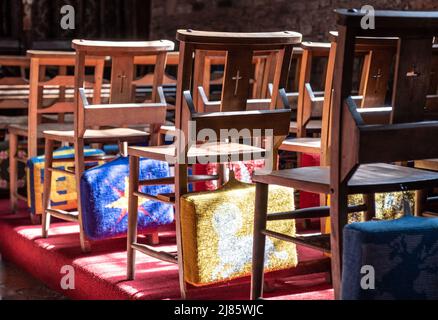 Cuscini ricamati di preghiera sul retro di sedie di legno nella Cockington Court Church, Devon. Foto Stock