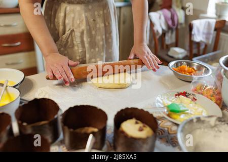 Donna che stenderà l'impasto con la spilla in cucina. Donna stenderà l'impasto per le torte di Pasqua Foto Stock