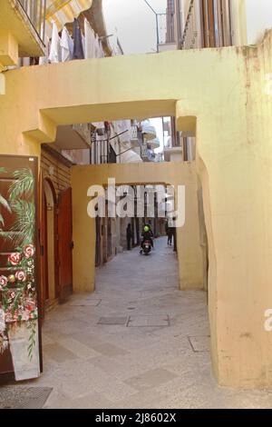 Stretto passaggio con serie di contrafforti tra edifici nel centro storico di Bari, Italia Foto Stock