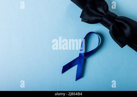 Direttamente sopra il colpo del nastro blu di consapevolezza del cancro della prostata con bowtie nera sopra lo sfondo blu Foto Stock