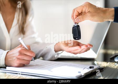 Ricezione della chiave dell'auto da parte dei venditori. Cliente e proprietario Foto Stock