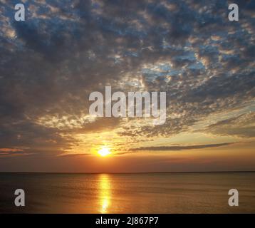 Magnifico tramonto da sogno sulla superficie del lago sullo sfondo del sole e delle nuvole colorate Foto Stock