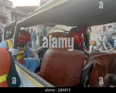 Gujranwala. 13th maggio 2022. La foto del cellulare scattata il 13 maggio 2022 mostra i soccorritori che lavorano ad un luogo di incidente stradale nel distretto di Gujranwala della provincia orientale del Punjab del Pakistan. Almeno 12 persone sono state uccise e 10 altre ferite in un incidente stradale il venerdì nel distretto di Gujranwala, nella provincia orientale del Punjab in Pakistan, i media locali hanno riferito. Secondo i rapporti, l'incidente si è verificato nelle prime ore in cui un camion del dumper che accelera si è schiantato con due furgoni passeggeri uno dopo l'altro sulla strada di Hafizabad vicino alla zona di Kot Ladha di Gujranwala. Credit: Str/Xinhua/Alamy Live News Foto Stock