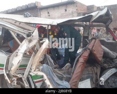 Gujranwala. 13th maggio 2022. La foto del cellulare scattata il 13 maggio 2022 mostra i soccorritori che lavorano ad un luogo di incidente stradale nel distretto di Gujranwala della provincia orientale del Punjab del Pakistan. Almeno 12 persone sono state uccise e 10 altre ferite in un incidente stradale il venerdì nel distretto di Gujranwala, nella provincia orientale del Punjab in Pakistan, i media locali hanno riferito. Secondo i rapporti, l'incidente si è verificato nelle prime ore in cui un camion del dumper che accelera si è schiantato con due furgoni passeggeri uno dopo l'altro sulla strada di Hafizabad vicino alla zona di Kot Ladha di Gujranwala. Credit: Str/Xinhua/Alamy Live News Foto Stock