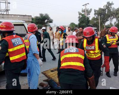 Gujranwala. 13th maggio 2022. La foto del cellulare scattata il 13 maggio 2022 mostra i soccorritori che lavorano ad un luogo di incidente stradale nel distretto di Gujranwala della provincia orientale del Punjab del Pakistan. Almeno 12 persone sono state uccise e 10 altre ferite in un incidente stradale il venerdì nel distretto di Gujranwala, nella provincia orientale del Punjab in Pakistan, i media locali hanno riferito. Secondo i rapporti, l'incidente si è verificato nelle prime ore in cui un camion del dumper che accelera si è schiantato con due furgoni passeggeri uno dopo l'altro sulla strada di Hafizabad vicino alla zona di Kot Ladha di Gujranwala. Credit: Str/Xinhua/Alamy Live News Foto Stock