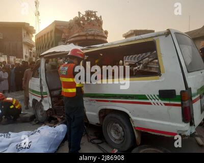 Gujranwala. 13th maggio 2022. La foto del cellulare scattata il 13 maggio 2022 mostra i soccorritori che lavorano ad un luogo di incidente stradale nel distretto di Gujranwala della provincia orientale del Punjab del Pakistan. Almeno 12 persone sono state uccise e 10 altre ferite in un incidente stradale il venerdì nel distretto di Gujranwala, nella provincia orientale del Punjab in Pakistan, i media locali hanno riferito. Secondo i rapporti, l'incidente si è verificato nelle prime ore in cui un camion del dumper che accelera si è schiantato con due furgoni passeggeri uno dopo l'altro sulla strada di Hafizabad vicino alla zona di Kot Ladha di Gujranwala. Credit: Str/Xinhua/Alamy Live News Foto Stock