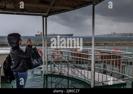Istanbul, Turchia. 7th maggio 2019. Una giovane donna fotografa la tempesta da un traghetto mentre una nave da carico sullo sfondo attende il suo turno per entrare nello stretto del Bosforo. Il trasporto marittimo con traghetti è una specificità di Istanbul. Nonostante il tunnel più profondo del mondo sotto il Bosforo per la metropolitana e l'inaugurazione del nuovo ''Canakkale 1915 Bridge'' nel marzo 2022, la popolazione e il 2019 sindaco recentemente eletto di Istanbul stanno promuovendo il trasporto marittimo per alleviare il traffico stradale e ridurre le emissioni del CO2. (Credit Image: © Laurent Coust/SOPA Images via ZUMA Press Wire) Foto Stock