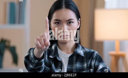 Asian ragazza ritratto donna arrabbiata aggressiva signora ondeggiante indice dito negativo no risposta non segno divieto di proibire disaccordo Foto Stock