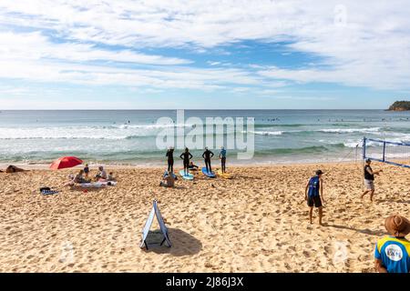 Lezioni di surf per principianti in corso a Manly Beach a Sydney, NSW, Australia il giorno d'autunno del cielo blu Foto Stock