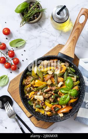 Vegetariano wok mescolare friggere. Gamberi di mare, calamari, seppie stufati di verdure e salsa all'aglio su un tavolo di marmo. Vista dall'alto, disposizione piatta. Foto Stock